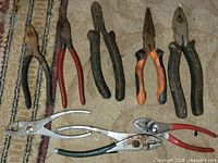 Eight pliers and cutters laid out on carpet