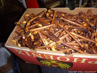 Box filled with cylindrical brown wooden beads and some tan beads