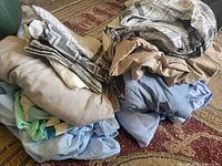 Two stacks of assorted folded sheets showing colours and patterns