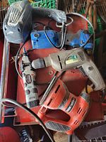 Group of five corded power tools on red surface