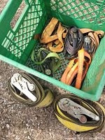 Two coiled yellow heavy-duty ratchet straps and basket with additional straps