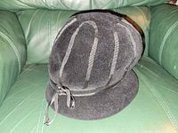 Overall view of black felt hat showing ribbon loops and bow