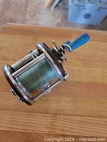 Side view of Penn 109 reel showing Bakelite side plate and spool with green line