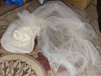 Full view of hat showing lace crown, organza brim, bow, and extended veil