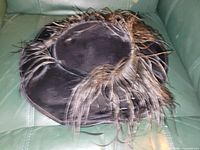 Top view of black fabric hat with feather trim