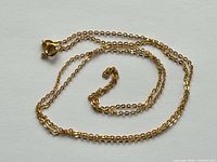 Gold chain coiled showing links and clasp