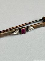 Close-up of bar pin showing stones and metal patina