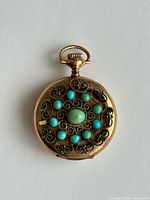 Decorative case back with turquoise cabochons and filigree