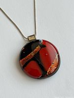 Front view of pendant on chain showing color and design