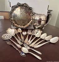 Front view of full lot: tray, pitcher, assortment of flatware