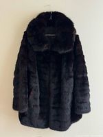 Front view of dark brown fox fur coat on hanger