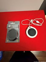 Both teacup warmers side-by-side, one packaged, one loose with cord