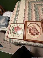 Overall view of both framed floral pictures on bed