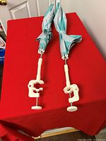 Both clamp-on beach chair umbrellas folded showing clamps and shafts
