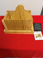 Full view of bamboo bread slicer with two manuals on table