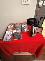 Table with approximately 25 CDs, visible Glenn Miller CD and two black CD wallets