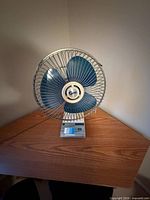 Front view of fan showing blades, cage, base and control slider