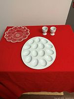 All items: pink glass devilled egg platter, white ceramic devilled egg tray, two white ceramic egg cups