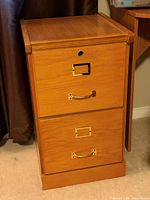 Front view of two-drawer faux wood filing cabinet showing handles and label frames