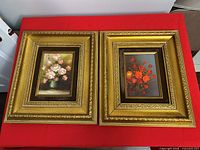 Overall view of two identical gold frames with distinct floral artworks