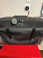 Front view of soft luggage bag showing buckle straps and logo patch