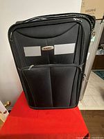 Front view of Missil suitcase showing logo, front pockets and fabric texture