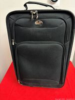 Front view showing overall suitcase design, front pocket, handles and wheels