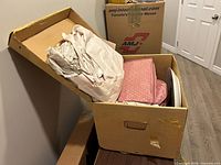 Full view of open moving box showing packing paper and partially visible contents