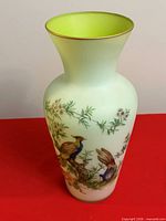 Front view of light green vase with bird and foliage painting