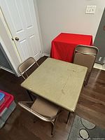 overhead view of square folding table and three folding chairs