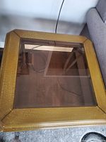 Top view of one square table showing glass inset and gold wooden frame