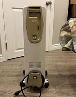 Front view of DeLonghi heater showing controls, vents, cord wrap and casters