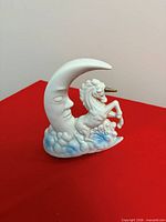 front view of ceramic music box showing unicorn, crescent moon, and cloud base
