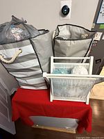 Two fabric totes filled with bagged yarn and a wooden yarn holder on a table