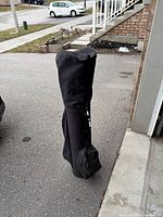Golf bag inside full-length zip travel cover standing upright