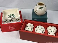 Overall lot showing napkin holder, three votive holders in box, and vase on its box