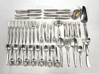 Full layout of all 53 sterling flatware pieces and baby cup