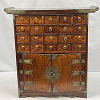 Front view showing 20 drawers, double doors, brass hardware