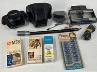 Full lot overview with cases, flashbulb packages, microphones, slide loader, projector lamp and reels visible