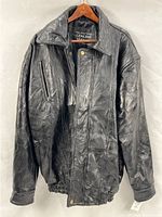 Front view of black patchwork leather bomber jacket on hanger