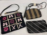 Three bags laid out: Betsey Johnson tic-tac-toe, Alan Edwards striped, unbranded beaded clutch