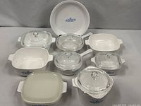 All nine Corning Ware vessels with lids arranged together