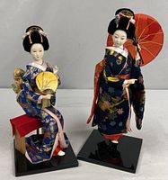 Two geisha dolls on black bases, full view