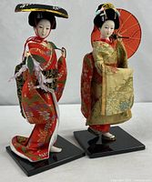Both Geisha dolls standing on bases