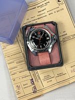 Watch in presentation box atop passport sheet