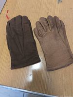 Both pairs of gloves laid flat showing exterior colors and styles