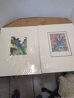 Both matted artworks side by side on table