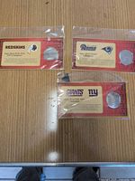Three packaged commemorative coins on tabletop