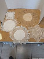 Overview of all five crocheted doilies on table