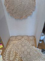 All five crocheted doilies displayed: round piece hung, others laid flat